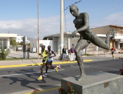 Runners in sync with the statue on the race course from Marathon to Athens. © www.PhotoRun.net