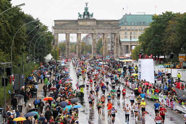 Thousands of fans cheer on the runners who braved the rains all the way to the finish. © www.PhotoRun.net