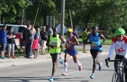 Allan Kiprono, Meb Keflezighi, and Lani Kiplagat, with KI’s Dick Resch on the leading bike. © Take The Magic Step