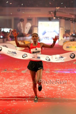 Ethiopia’s Mamitu Daska raises her arms in triumph as she breaks the finish line tape. © www.photorun.net